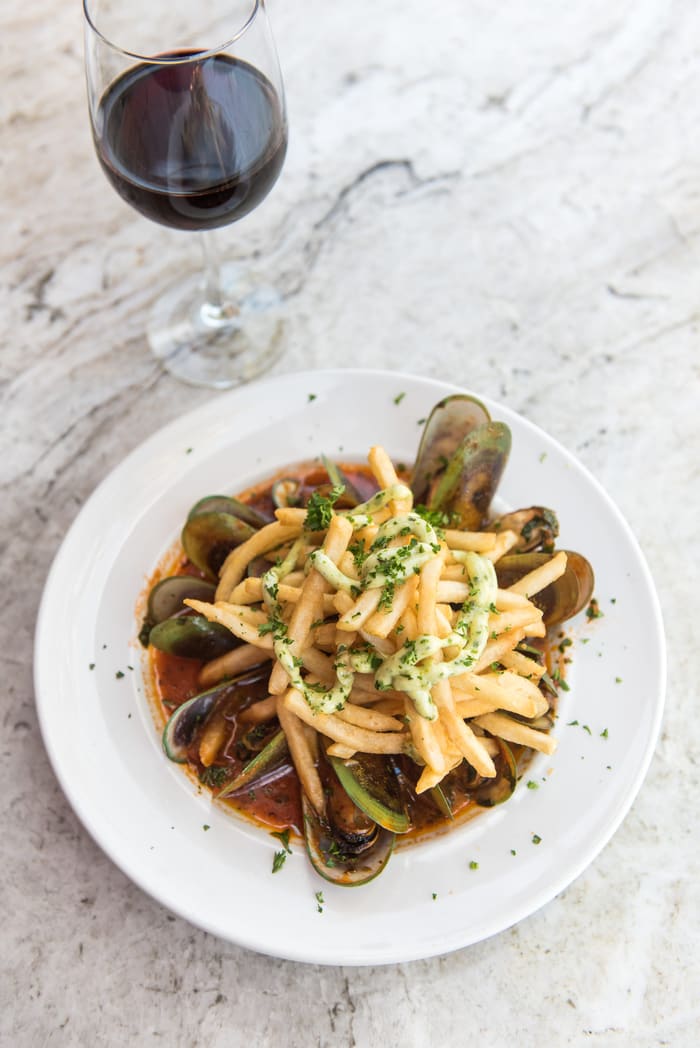 Mussels in white wine and tomato broth, piled with fries and lemon pesto aioli