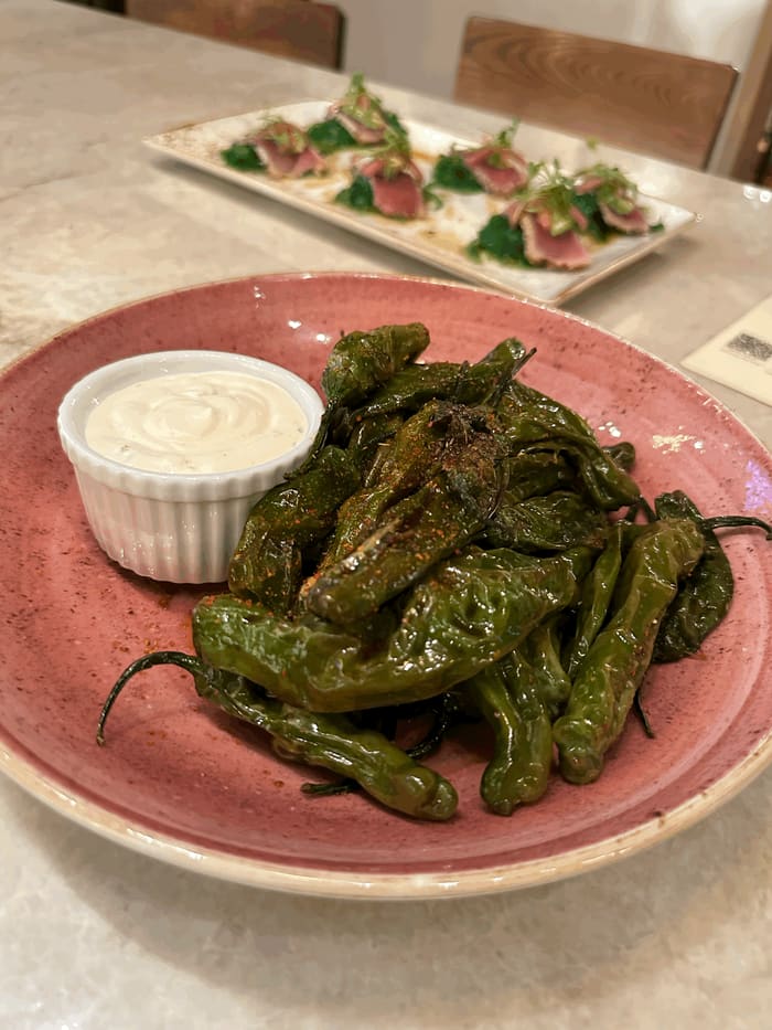 Blistered shishito peppers with pickled serrano aioli