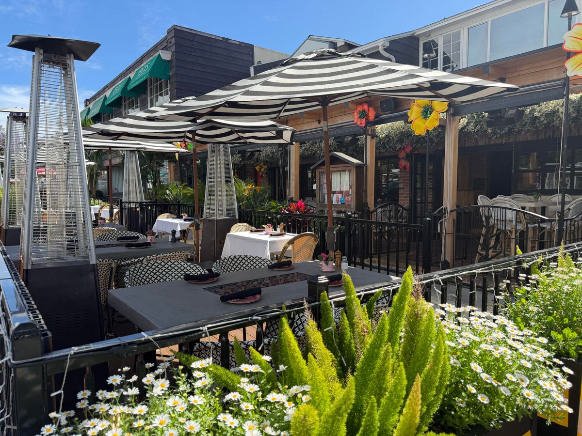 The street patio on Fay Avenue under striped umbrellas